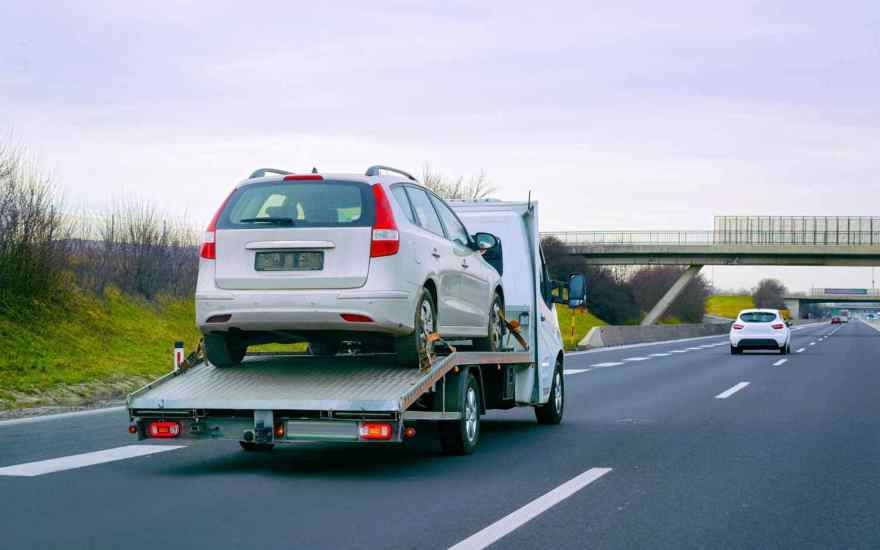 Car being loaded onto a single‑car trailer for delivery in the UK